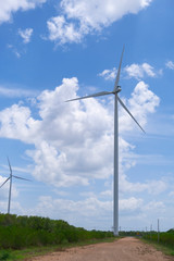 Fototapeta na wymiar Wind turbine farm to generate the electric power with blue sky and cloudy day