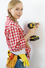 Woman drilling in wall