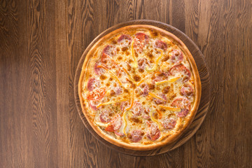 Tasty vegetable pizza with ham isolated on wooden background