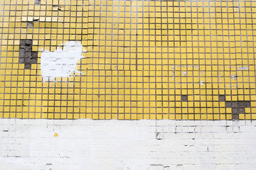 The wall of the house is made of yellow tiles. Sometimes painted white.
