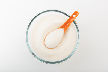 Sugar in glass bowl isolated on white background