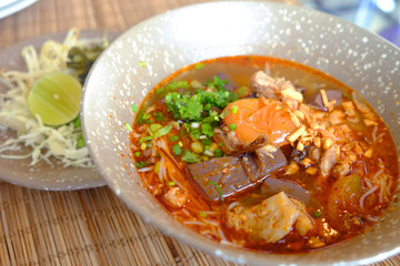 Traditional local noodle food in North region of Thailand and Southeast Asia countries, AKA Khao Soi, cooked with chicken or pork, and served with cabbage and lemon
