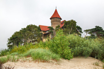 LEBA, POLAND - JULY 23, 2019: Neptun Castle on the Baltic Sea in Leba, Poland. In 1903 almost on the beach , the build of this interesting architectonically building was begun (completed in 1907). - obrazy, fototapety, plakaty