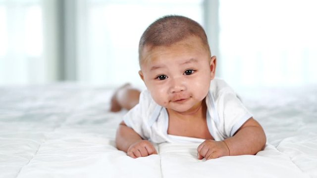 slow-motion of happy baby on a bed at home