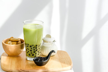 Bubble milk green tea with bubble topping for tea or other beverage on the wood table with...