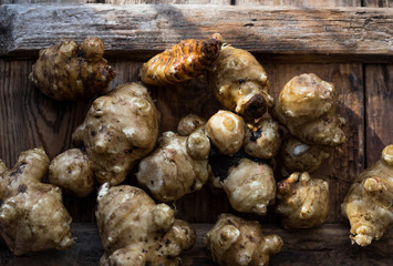 Whole ans sliced Jerusalem artichokes on a cutting board