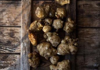 Whole ans sliced Jerusalem artichokes on a cutting board
