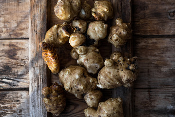 Whole ans sliced Jerusalem artichokes on a cutting board