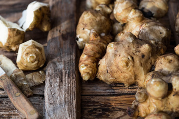 Whole ans sliced Jerusalem artichokes on a cutting board