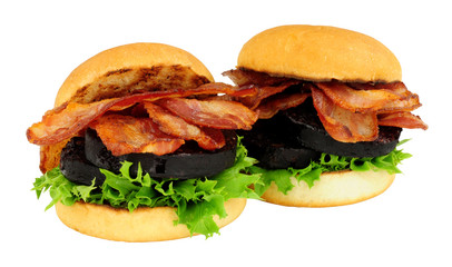 Fried bacon and black pudding sandwich rolls with lettuce isolated on a white background