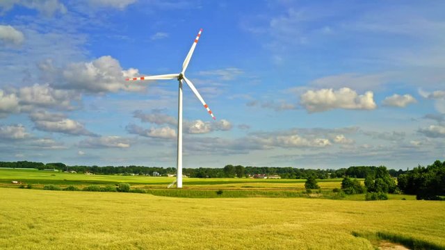 White wind turbine on field, aerial view in summer