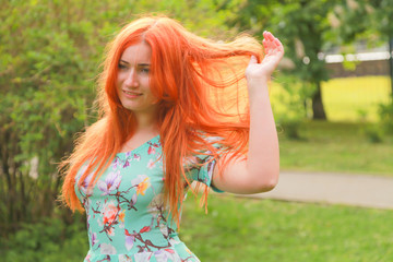 pretty redheaded girl walking in the summer park