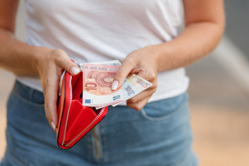 Female hands gets money from the wallet. Euro cash background.