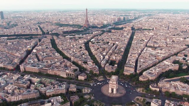 Aerial drone shot of the Cityscape of Paris, France with the Arc de Triomphe in the foreground and the famous Eiffel Tower in the background