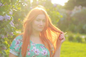 pretty redheaded girl walking in the summer park