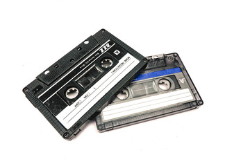 Two black cassettes on white background. Vintage audio tapes. Old-fashioned musical objects.