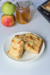 pieces of Apple pie on a white plate with honey.