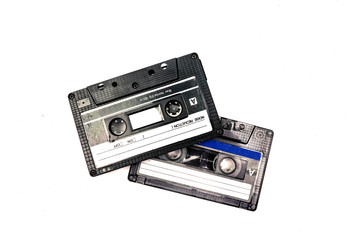 Two black cassettes on white background. Vintage audio tapes. Old-fashioned musical objects.