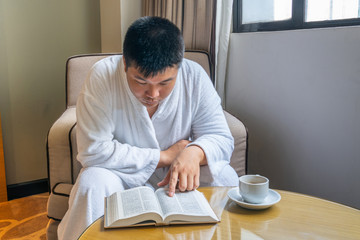 Businessman wearing bathrobe enjoy morning coffee and reading good book
