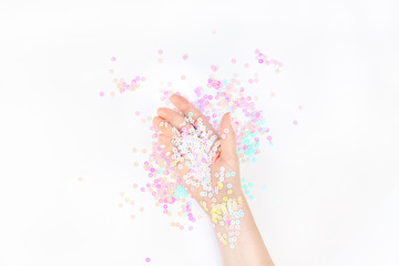 Fototapeta na wymiar Pearl pastel confetti sparkles with woman hand