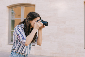 Young woman with camera taking photos in vacation