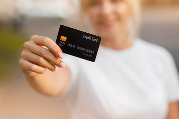 Girl's holding euro bills and credit card. Online shopping traveling around the wolrd