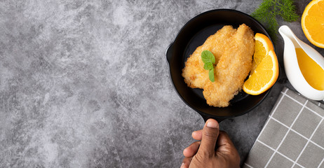 chef preparing fried fish with bread crumbs.