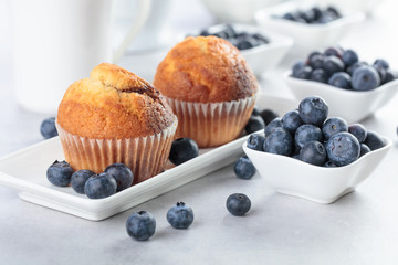 Muffins and blueberry on white table.