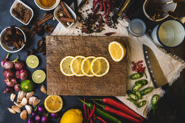Healthy food herbs. Spices for use as cooking ingredients on a wooden table with Fresh organic vegetables and raw material with Variety on the rustic table. Sliced ​​lemon on a wooden cutting board.