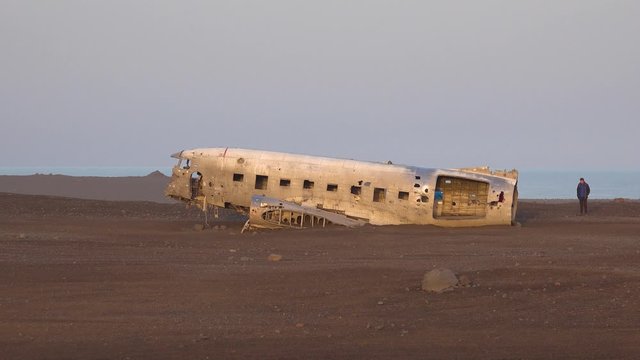 Tourists inspect a crashed U.S. Navy DC-3 on the black sands of Solheimasandur, Iceland.