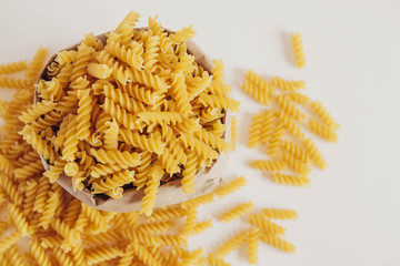 Spiral pasta in a paper bag on a white background. Top view. Copy, empty space for text