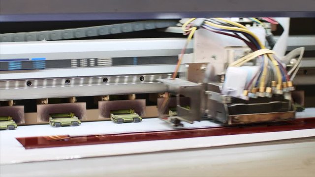 Industrial equipment for professional publishing. Process of printing colour picture production on inkjet printing press with ciss system, front view. Publishing business and industry.