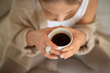Women hands holding cup with hot coffee