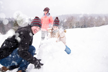 group of young people making a snowman