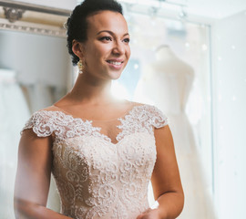 Beautifu bride choosing wedding dress in a wedding salon