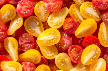 Fresh halves of Mexican cherry tomatoes. Sliced yellow and red cherry tomatoes.Background of many colorful cherry tomatoes. Cherry tomatoes top view.