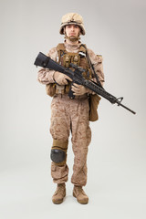 Studio shoot of modern infantry soldier, U.S. marine rifleman in combat uniform, helmet and body armor