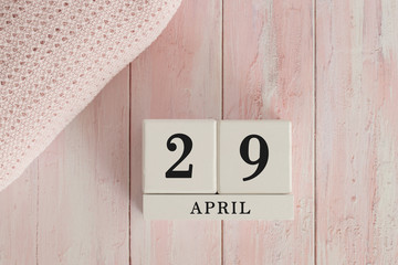29 April Date on Cubes. Date on painted pink wood, next to baby blanket. Theme of baby due dates and birth dates.