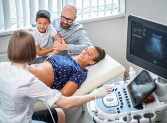 Pregnant woman and her family on utltrasonographic examination at hospital