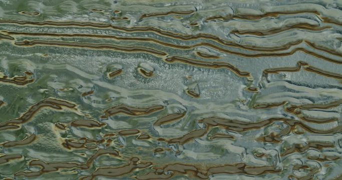 an organic structure of molten plastic is filmed with a slow camera pan almost looking like a landscape