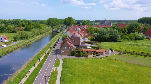 Aerial over canal and small town of Damme, Belgium and historic windmill.