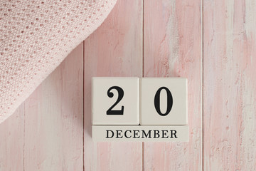20 December Date on Cubes. Date on painted pink wood, next to baby blanket. Theme of baby due dates and birth dates.