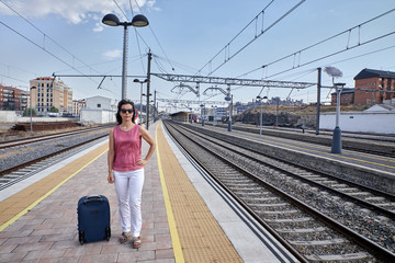 woman waiting for the train with a suitcase