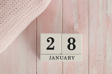 28 January Date on Cubes. Date on painted pink wood, next to baby blanket. Theme of baby due dates and birth dates.