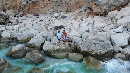 View from above, stunning aerial view of a beautiful beach full of beach umbrellas and people sunbathing and swimming on a turquoise water. Cala Gonone, Sardinia, Italy, Cala Galaritze beach