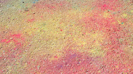 Pink and yellow holi color on ground