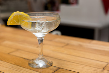 Wine glass with an alcoholic cocktail and lemon. Glass cup with alcohol and a slice of lemon and...