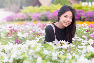 Thai women are sitting in the flower garden. Portrait of asian girl looking flowers at Bangkok , Thailand.