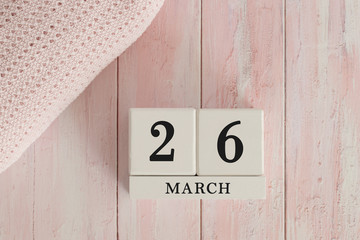 26 March Date on Cubes. Date on painted pink wood, next to baby blanket. Theme of baby due dates and birth dates.