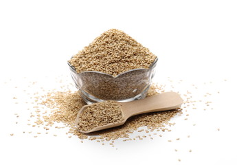 Organic integral sesame seeds with wooden spoon and glass bowl isolated on white background